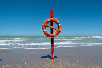 Lifeguard hut on beach against clear blue sky