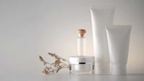 Close-up of glass bottle on table against white background