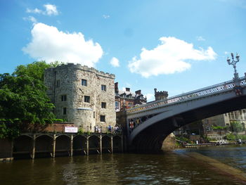 Low angle view of bridge over river against sky