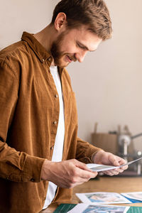 Full length of man using mobile phone while standing on table