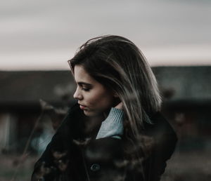 Close-up of young woman standing against sea