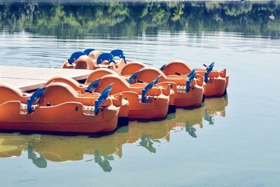 Orange kayaks moored on lake