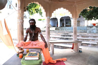 Portrait of young man sitting outside temple