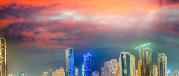 Panoramic view of illuminated buildings against sky during sunset