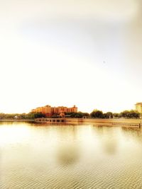 Scenic view of river by buildings against sky