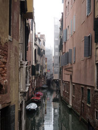 Boats in canal along buildings