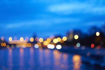 Defocused image of illuminated lights in sea at night