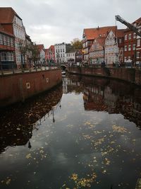 Canal amidst buildings against sky