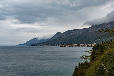 Scenic view of sea and mountains against sky