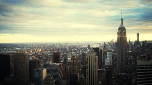 View of cityscape against cloudy sky