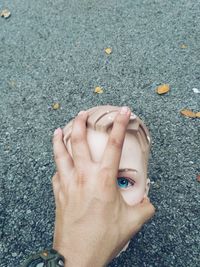 Close-up of woman hand on asphalt