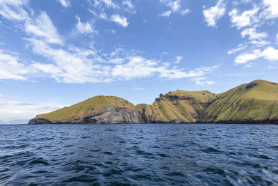 Scenic view of sea and mountains against sky