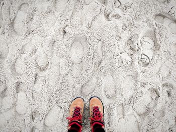 Low section of man standing on sand