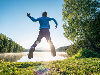 Crazy jumping boy celebrate freedom and make a fun at lake. crazy and amazing childood