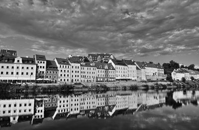 Reflection of buildings in river against sky