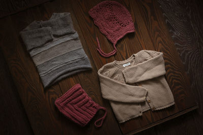 Children's wardrobe, knitted blouses and hats on a wooden background, the concept of autumn 