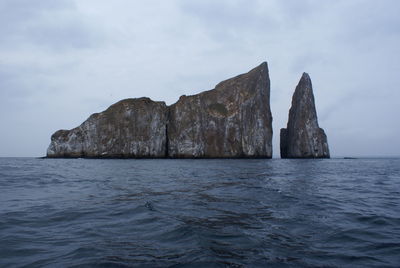 Rock formation in sea against sky