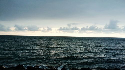 Scenic view of sea against cloudy sky