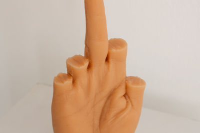 Close-up of woman holding hands over white background