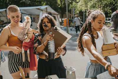 Female customers choosing products while shopping together at flea market