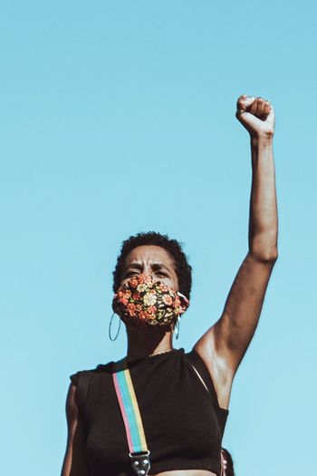 LOW ANGLE VIEW OF MAN AGAINST BLUE SKY