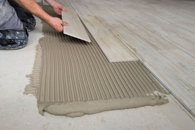 Low section of man working on hardwood floor