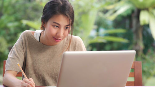 Portrait of young woman using mobile phone outdoors