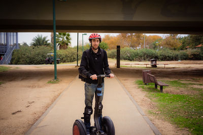 Portrait of young man with bicycle on road