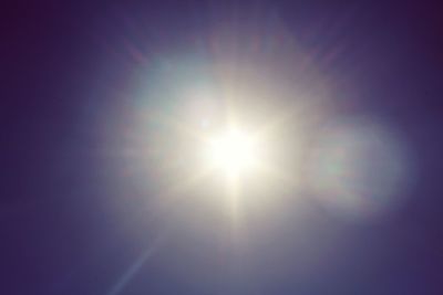 Low angle view of sun shining in sky