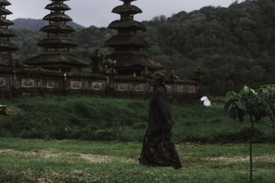 Rear view of woman standing on field