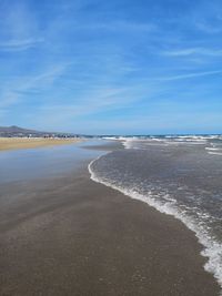 Scenic view of beach against blue sky