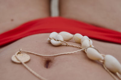 High angle view of woman in bikini at beach with jewerly on stomach