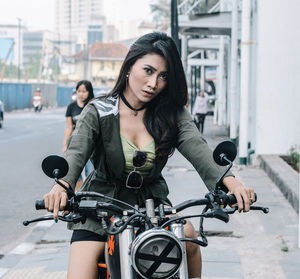 Portrait of young woman riding bicycle in city