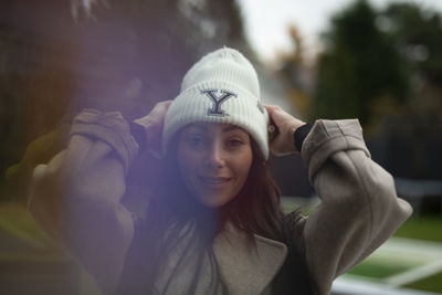 Portrait of young woman looking away while standing outdoors