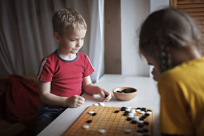 Sibling playing board game at home