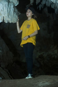 Portrait of young woman standing on rock