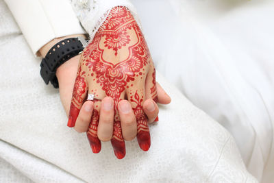 Midsection of bride and groom holding hands during wedding