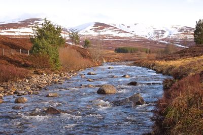 Scenic view of river amidst rocks against sky