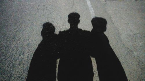 Shadow of man and woman standing on street