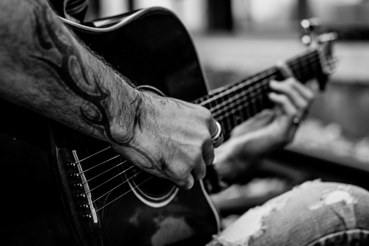 MAN PLAYING GUITAR AT MUSIC CONCERT