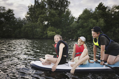 Siblings sitting on paddle board