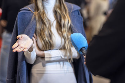 Tv journalist making media or vox populi interview with unrecognizable female person