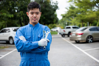 Portrait of young man standing on road