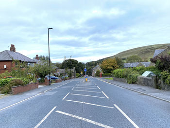 Looking down the, a672 road, with houses, cars, and hills in the distance in, oldham, lancashire, uk