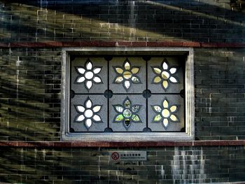 Low angle view of glass window on wall