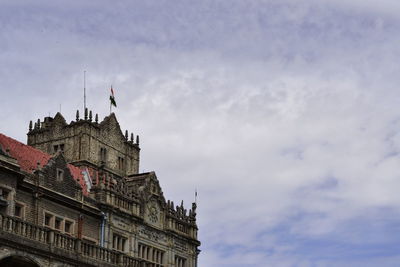 Low angle view of building against cloudy sky