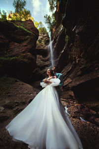 Couple in love against the backdrop of a waterfall. honeymoon trip. happy couple in the mountains