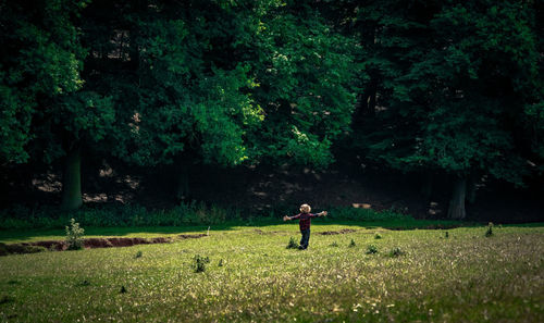 Full length of little boy running on field