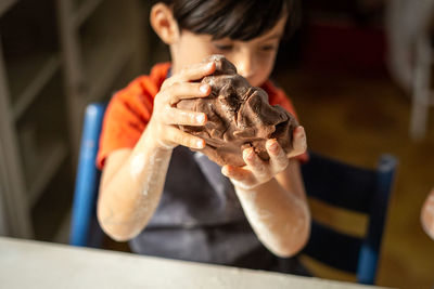 Close up of child hands kneading the chocolate dough