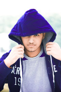 Close-up portrait of young man wearing hooded shirt